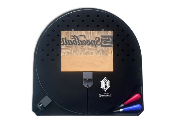 Top down view of black rotating bench hook with a carved block and two lino carving tools.