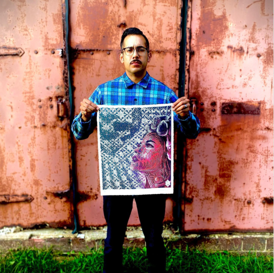 Top down view of black rotating bench hook with a carved block and two lino carving tools.